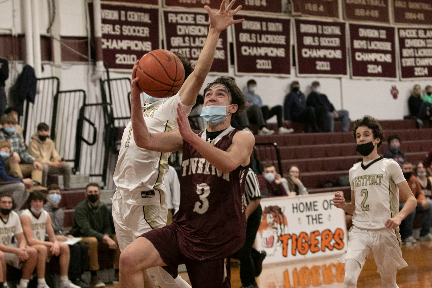 Ben Pacheco drives the lane for a layup guarded by Westport's Hunter Brodeur. 