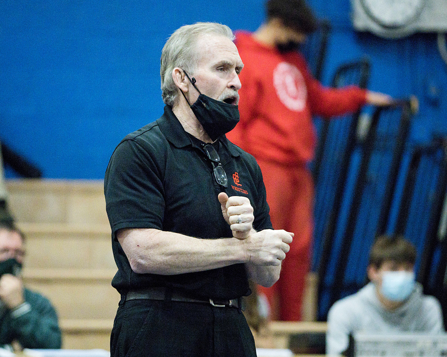 Head Coach Tom Galligan offers advice to a wrestler from the sidelines in Barrington.