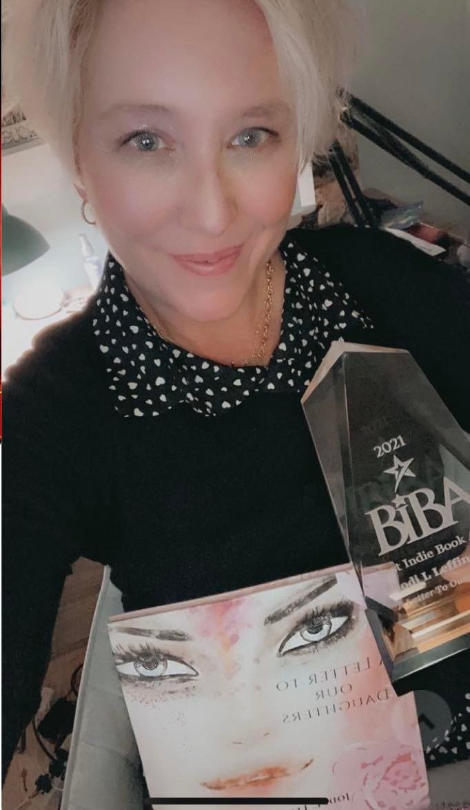Dr. Jodi L. Leffingwell holding a copy of her book, ‘A Letter To Our Daughters’ and the 2021 BIBA award for non-fiction.