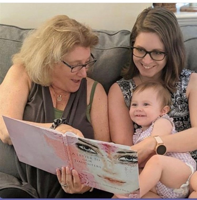 Jennifer Herman reads the book to her infant daughter.