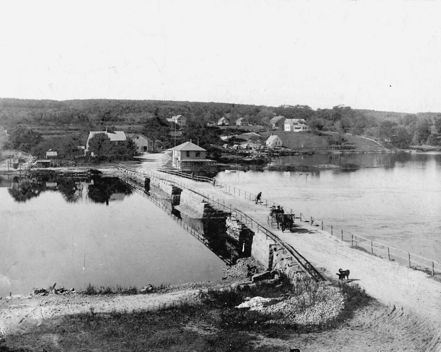A horse-drawn buggy sets out across an earlier version of Hix Bridge more than a century ago. When the bridge was rebuilt after later hurricanes and on other occasions, rubble from the pilings was dumped alongside.