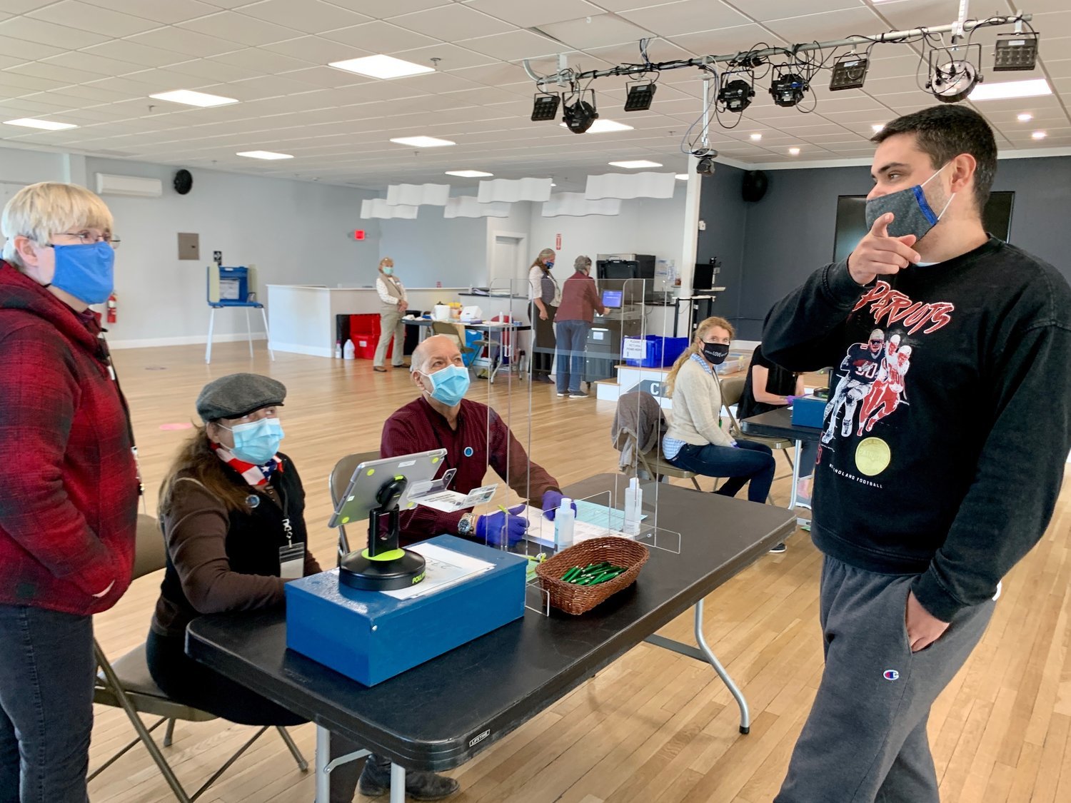 Election officials Elen Vadney (left) Debra Cardoza, and Gerry Kempen, working at CFP Arts, Wellness, and Community Center in Common Fence Point, help voter Ross Harrington during the November 2020 election.
