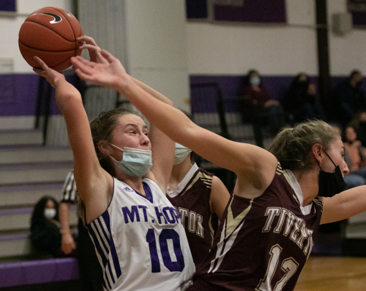 Reyn Ferris (left) reaches back to snag a rebound with Tiverton's Molly Richardson (right).