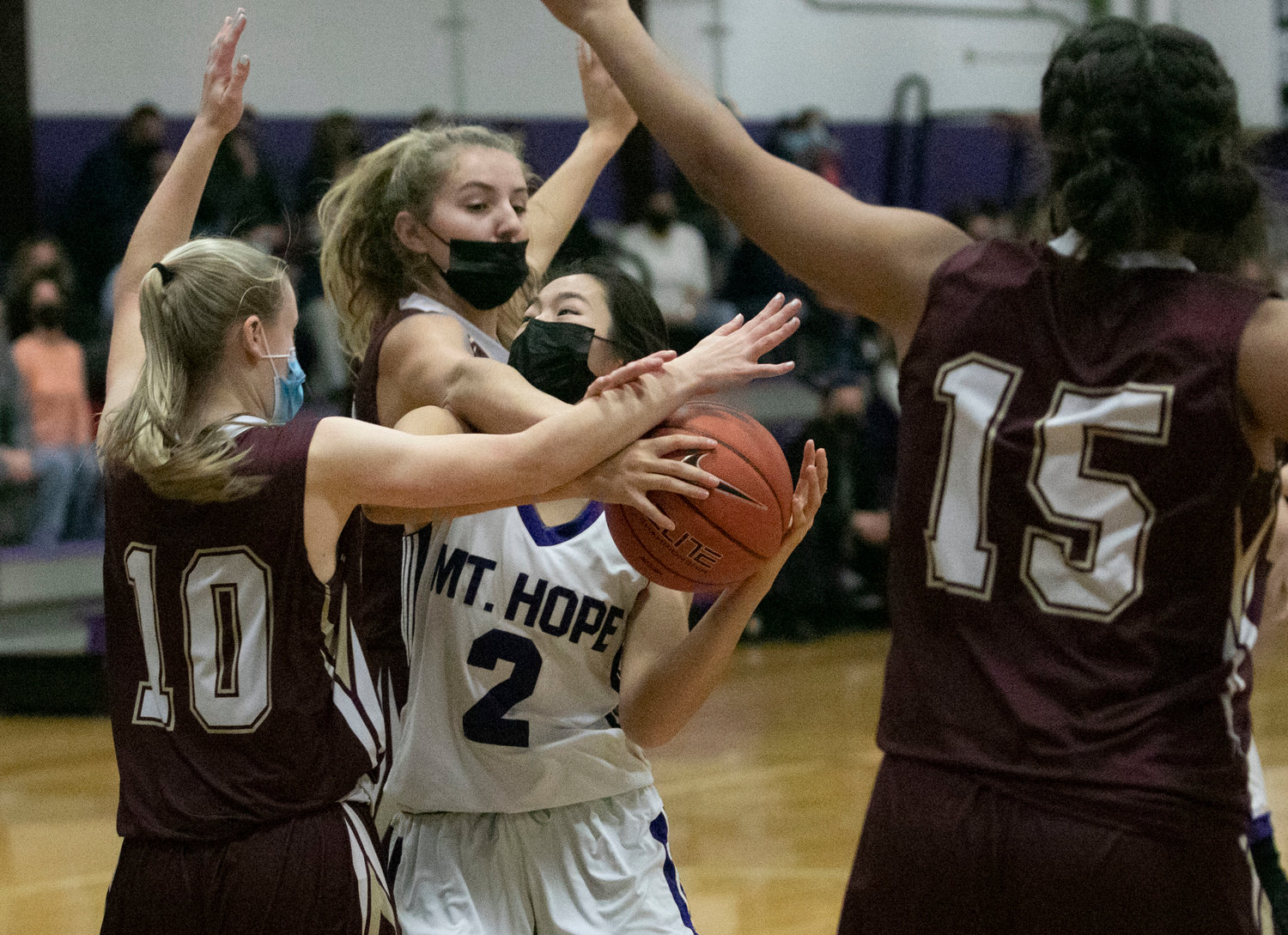 Tiverton defenders stop Elsa White as she drives in for a layup. 