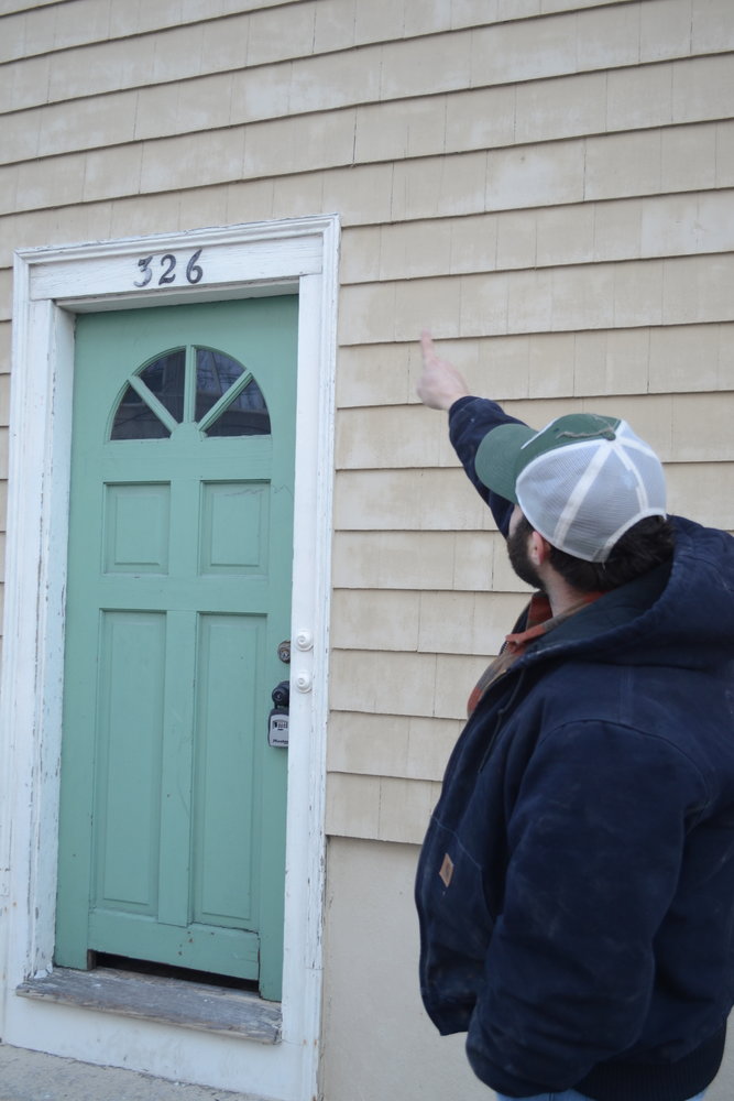 Zak Fenster points to an area of his historic property on Thames Street in Bristol. He claims he ran afoul of problems with the Historic District Commission regarding a patio and a driveway, and now two of the members are recusing themselves from any matters involving him following a complaint he has made to the Town Council.