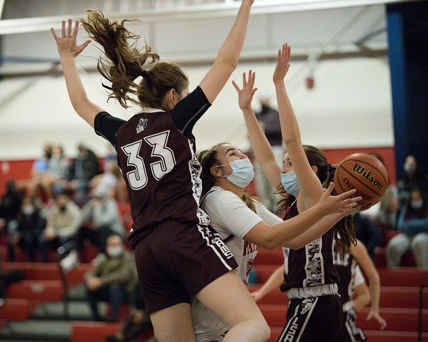 The Patriots’ Emily Maiato is sandwiched by a pair of La Salle defenders en route to the basket.