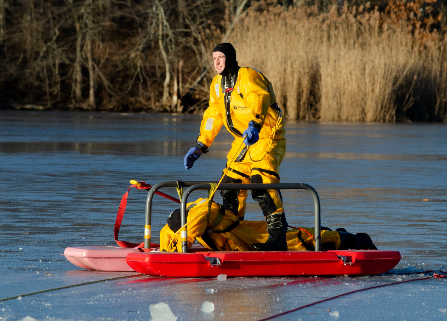 Barrington firefighter Pat Reihl pulls probationary firefighter Jared Pedro from the icy water at Brickyard Pond during an ice rescue training session on Friday afternoon.