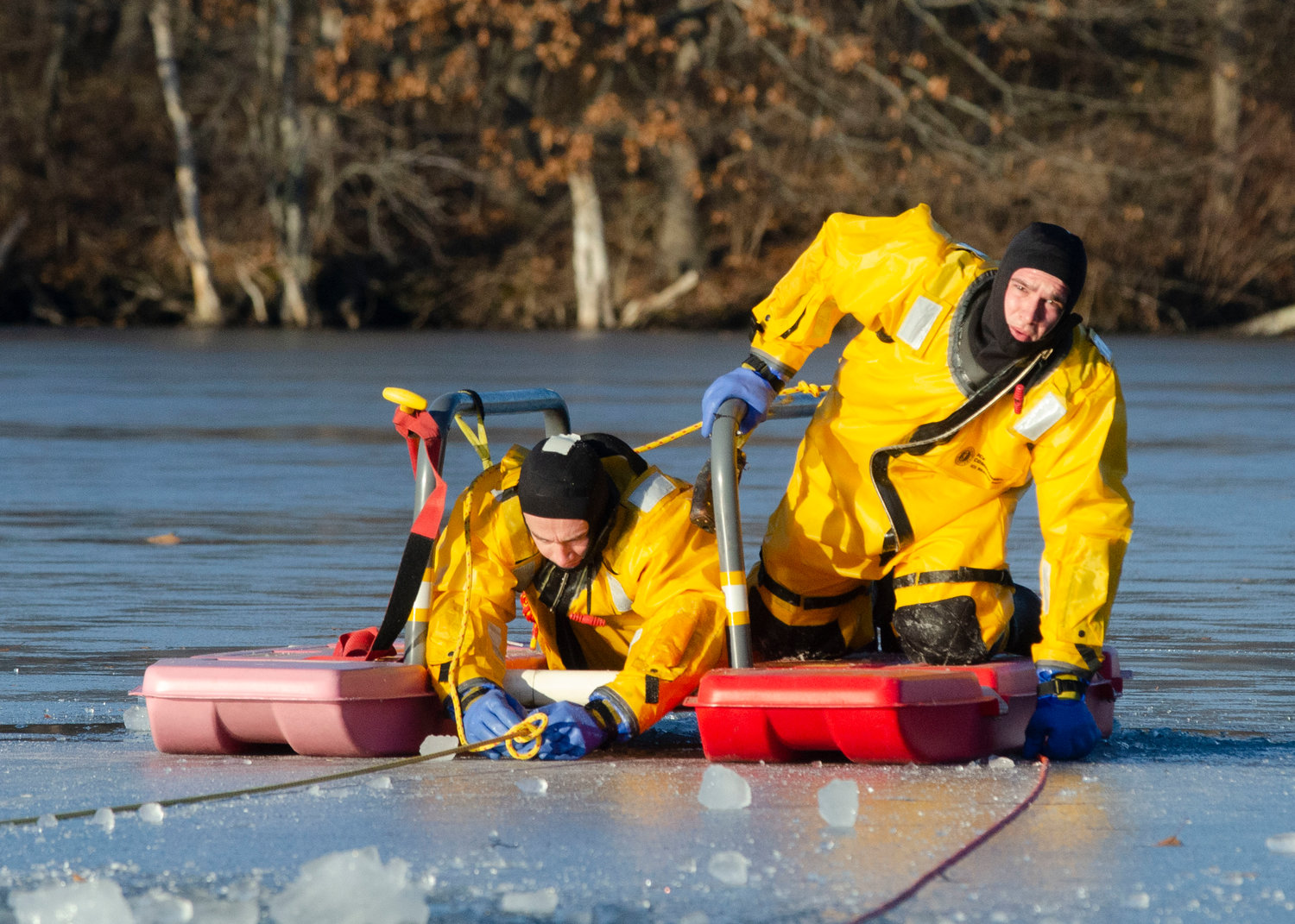 Probationary fireman Jared Pedro gives the signal to be pulled back to shore, once he loads firefighter Brian Masse safely onto the sled during an ice rescue training at Brickyard Pond on Friday afternoon.