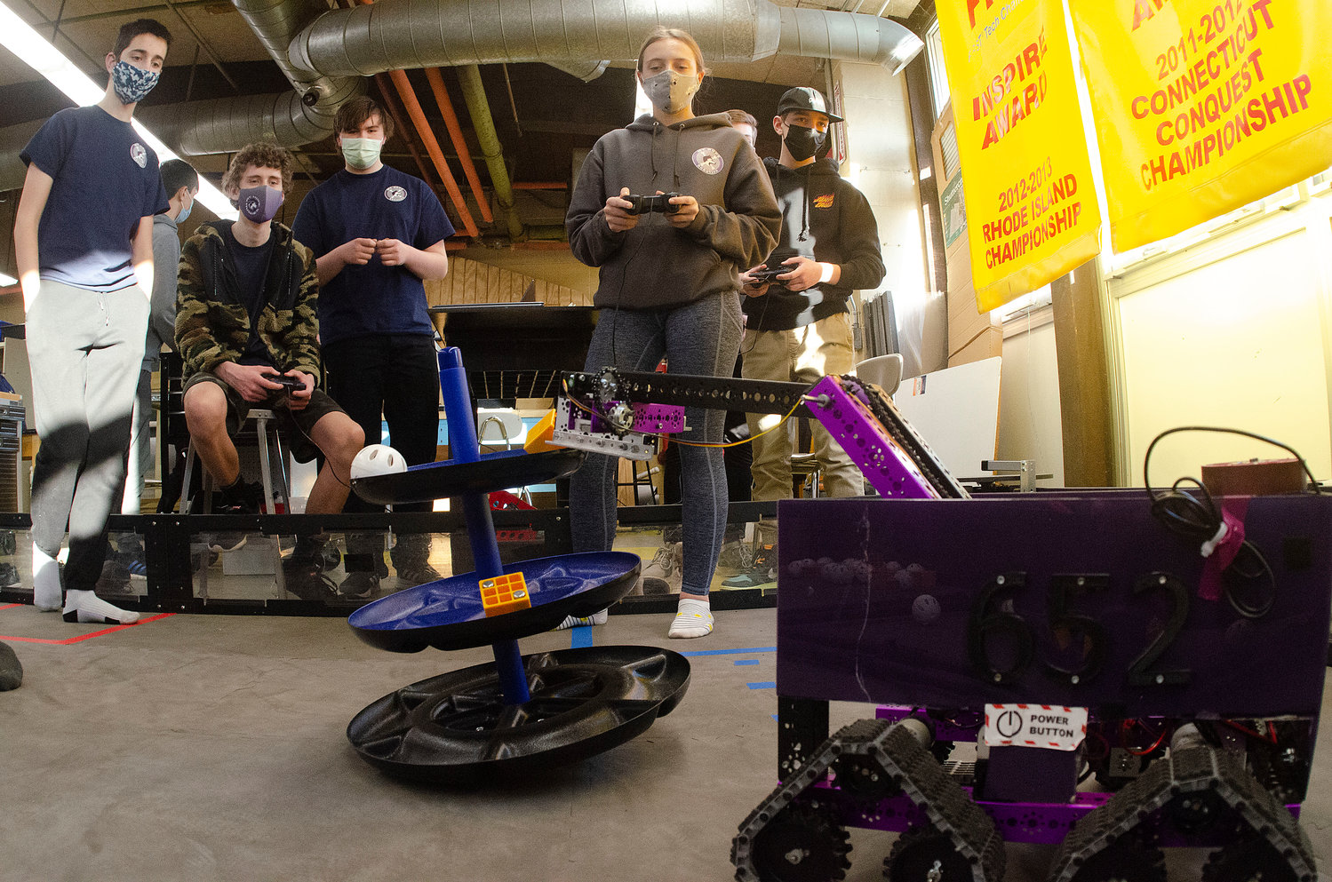 Samuel Howard (left, seated) and Alice Grantham practice with their team's robots in the arena.