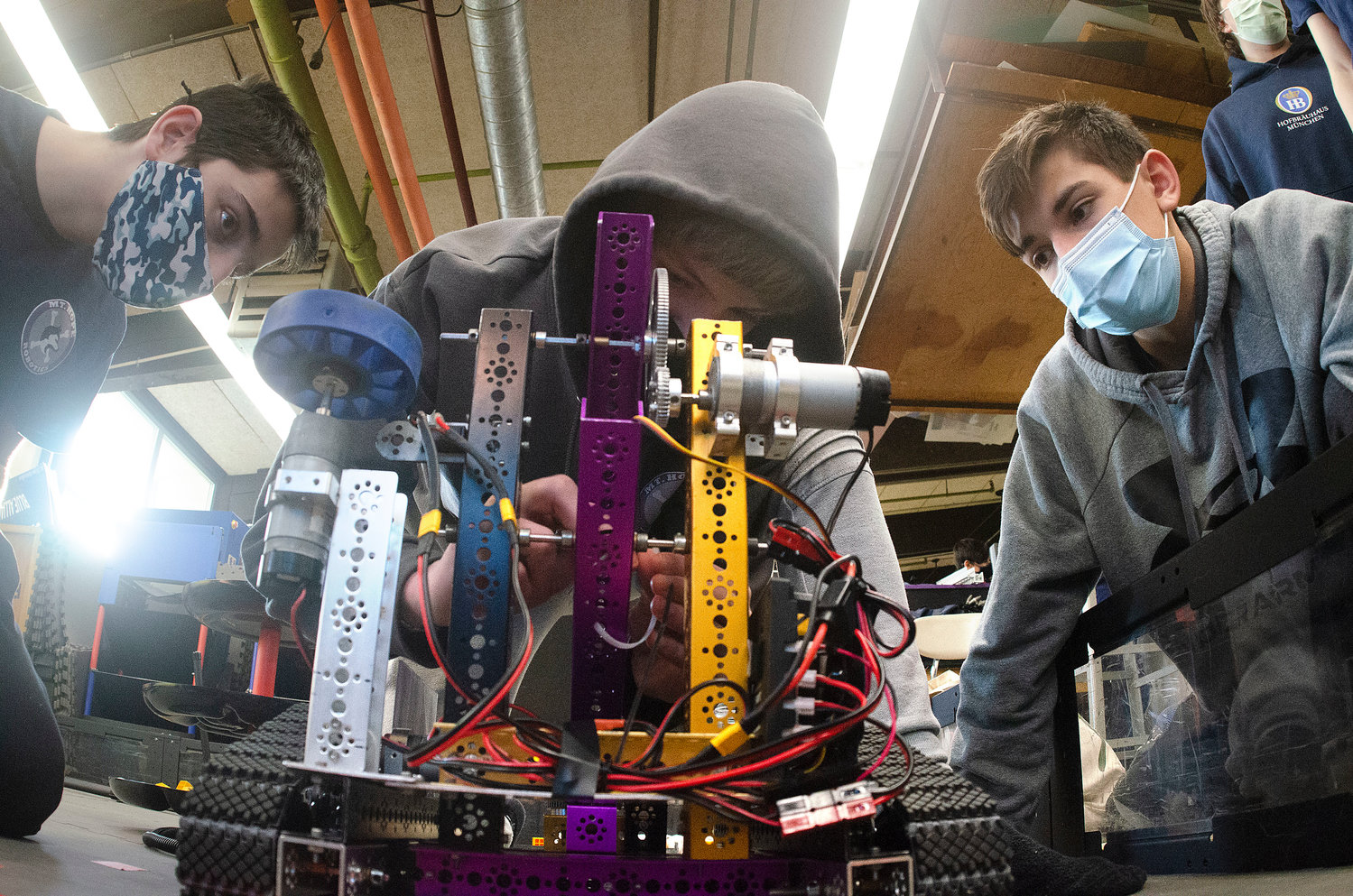 Michael Thibault and Chris Sousa repair their robot after a breakdown in the arena.
