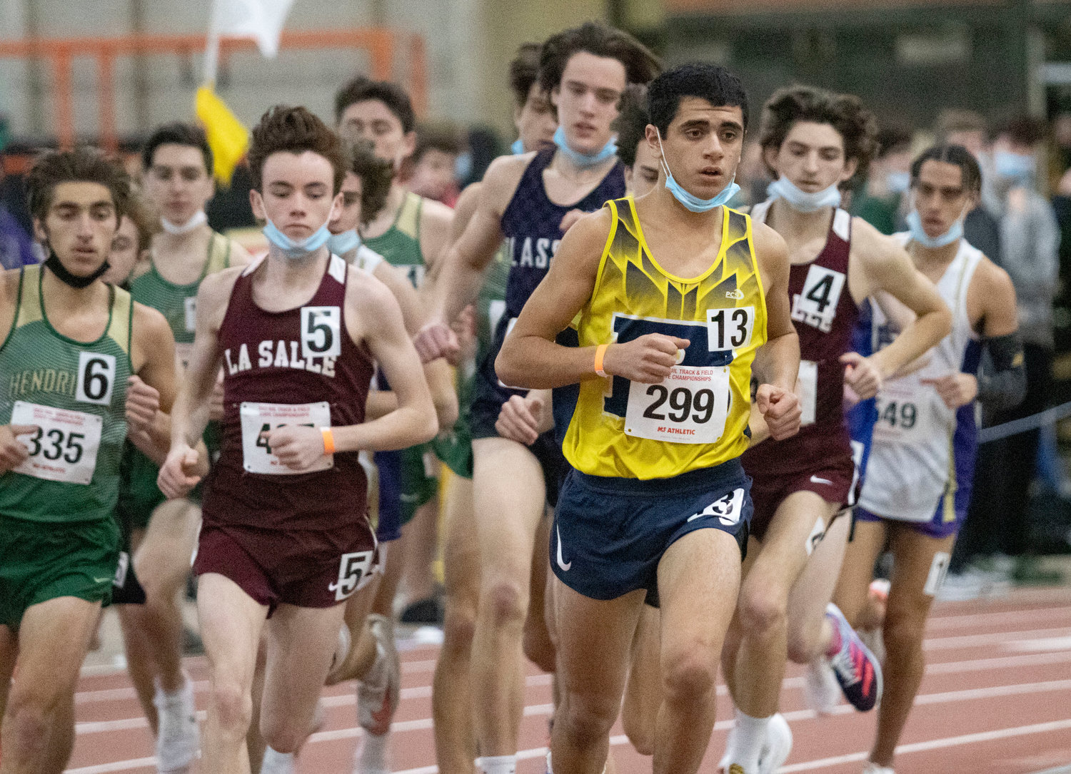 Brandon Piedade (number 299), shown running in an indoor track meet last year, leads the Barrington High School boys cross country team this fall.