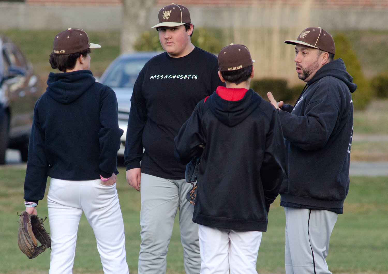 Wildcats head coach Jason Pacheco speaks to his young infield during a scrimmage game against Tiverton on Wednesday.