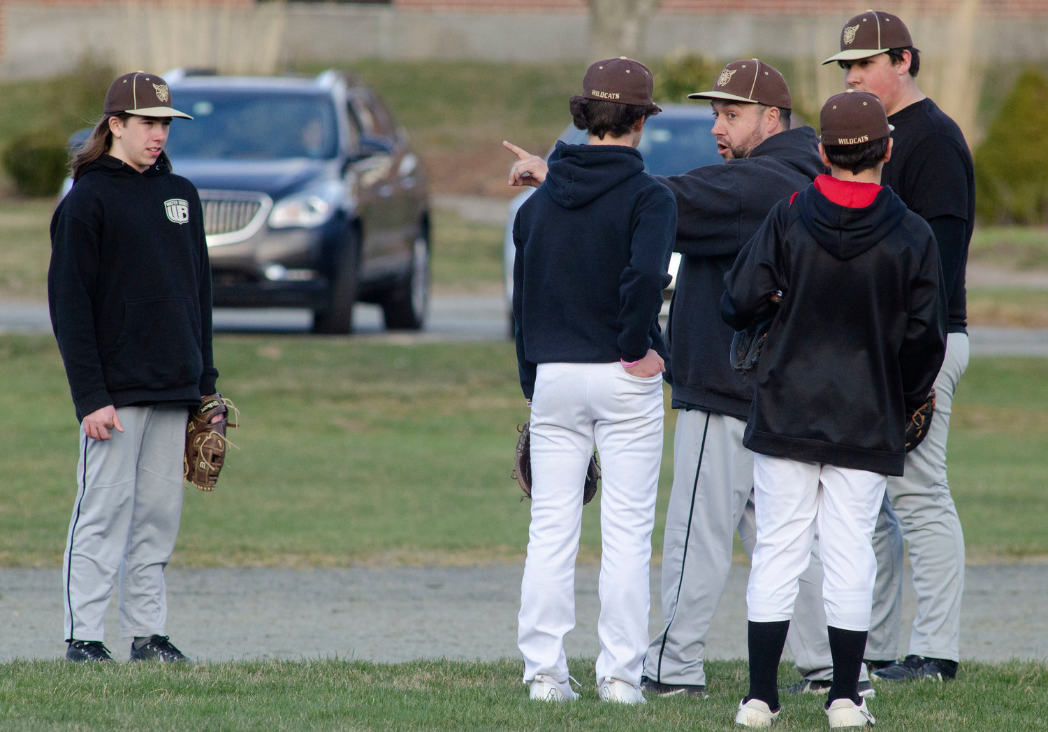 Wildcats head coach Jason Pacheco speaks to his young infield during a scrimmage game against Tiverton on Wednesday.