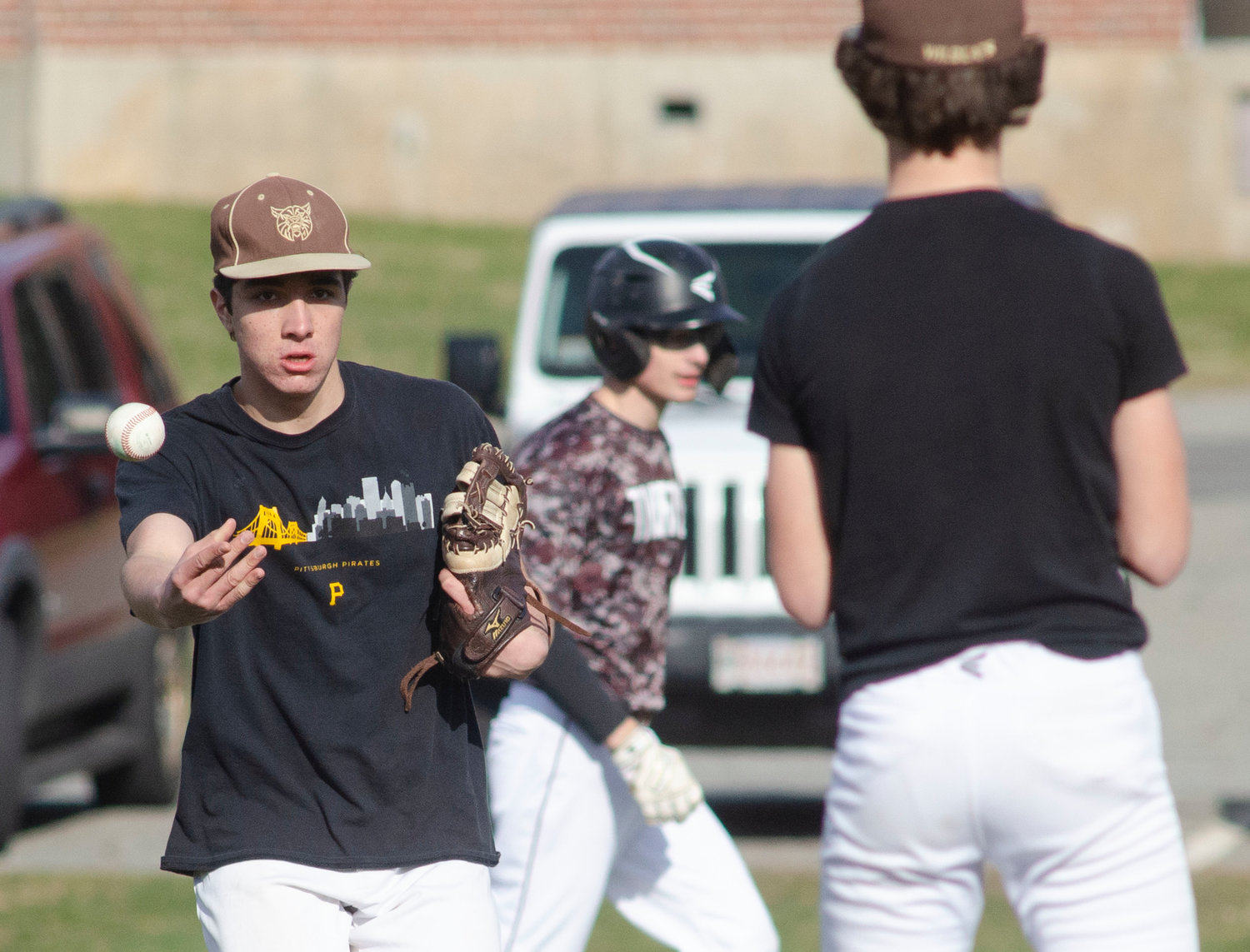 Max Morotti playing first base, flips the ball to pitcher Max Gallant after recording an out.