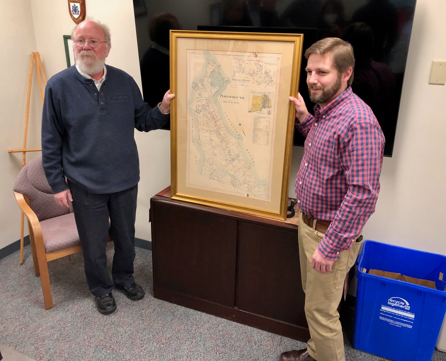 Town Planner Gary Crosby (left) and Assistant Planner Mike Asciola pose with a circa 1900-1905 map of Portsmouth that was gifted to Asciola, who’s taken a planning job in New Hampshire.