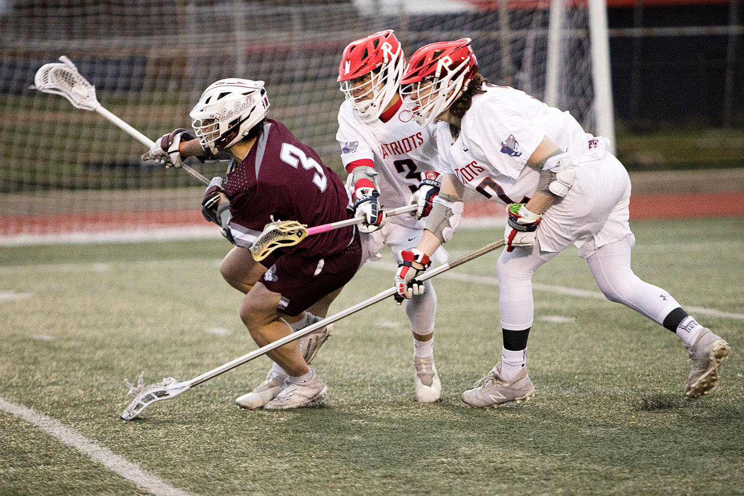 Marcus Evans and Joe Rocco (right) pressure a La Salle opponent from behind.