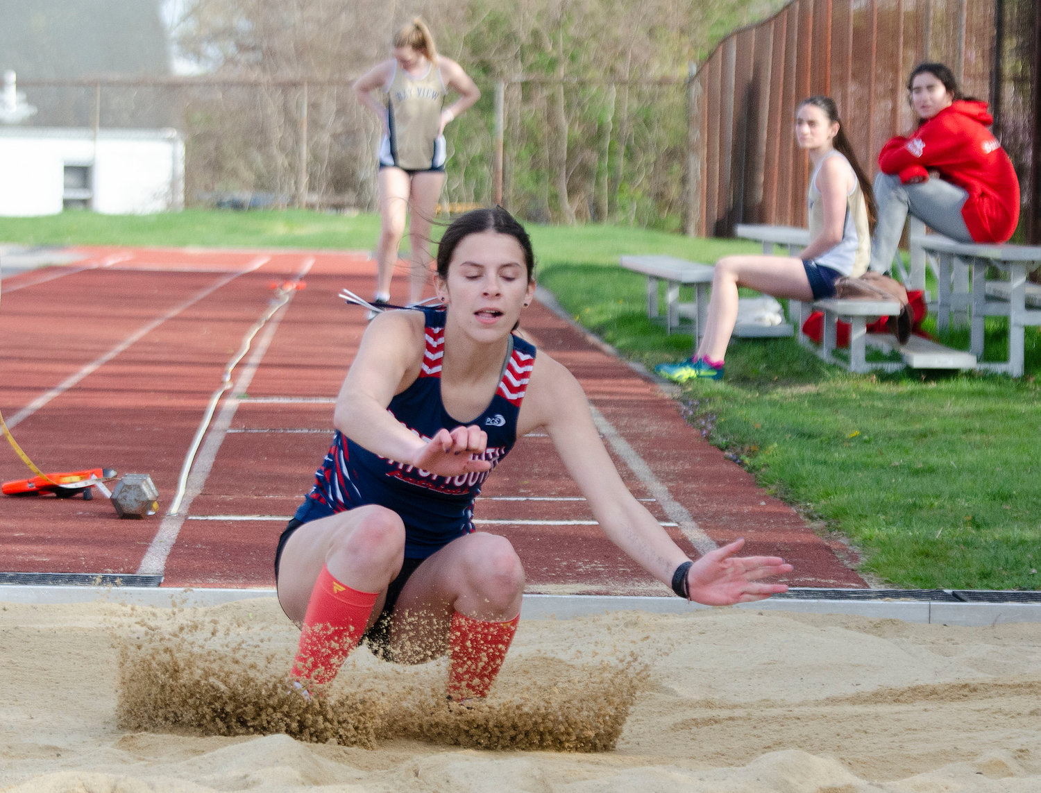 Katie Spaner splash-lands in the sand pit during the long jump event.