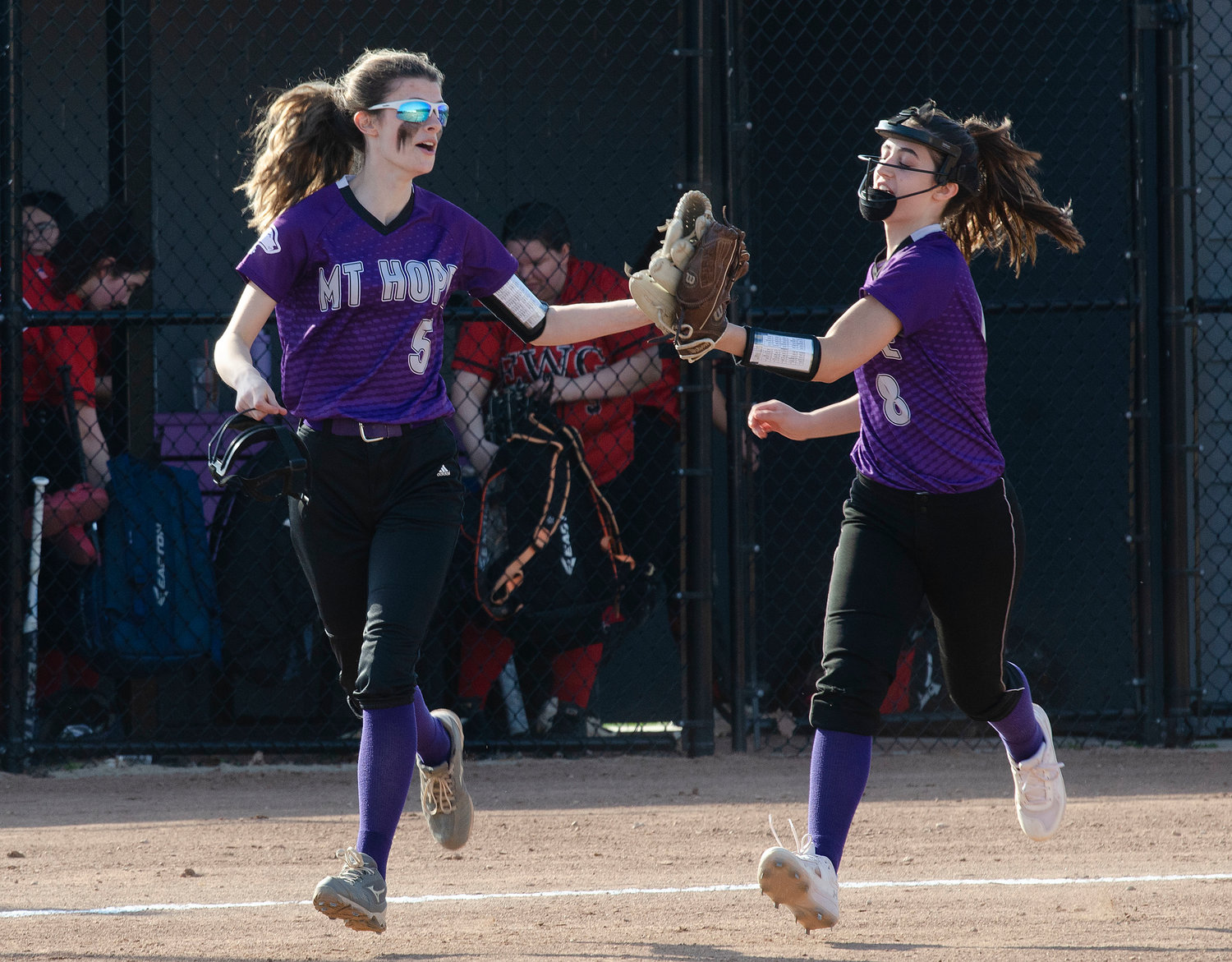 Huskies third baseman Sydney Crowell gets a glove bump from shortstop Julia Allen after the home win over Exeter-West Greenwich.