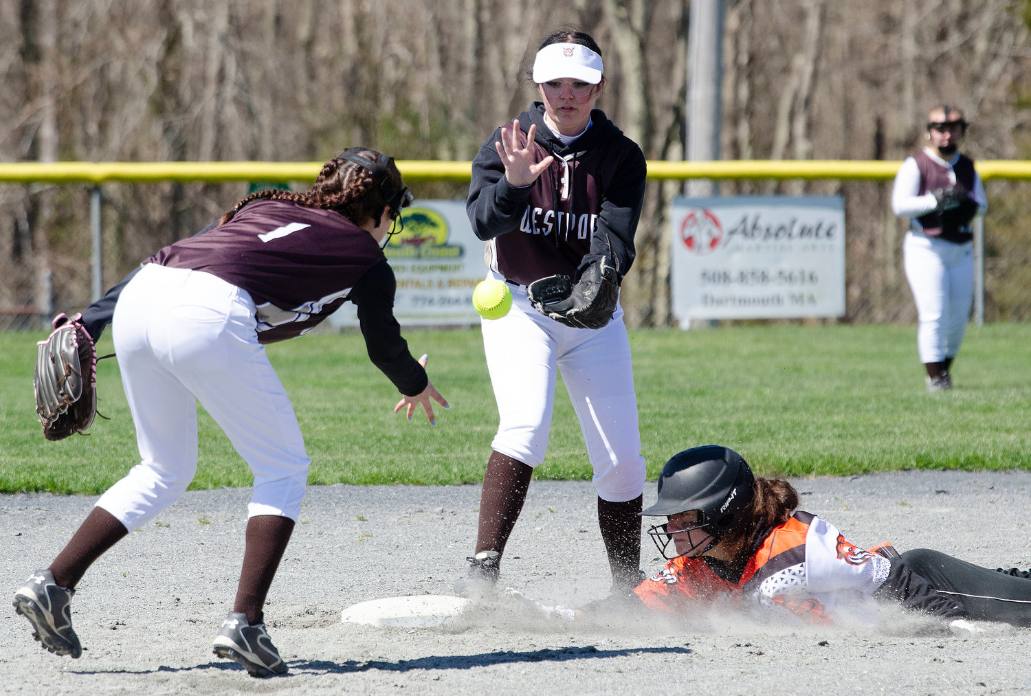 Shortstop Julia George (left) dishes the ball to second baseman Isabel Berube (middle) as a Diman player slides safely into second base.