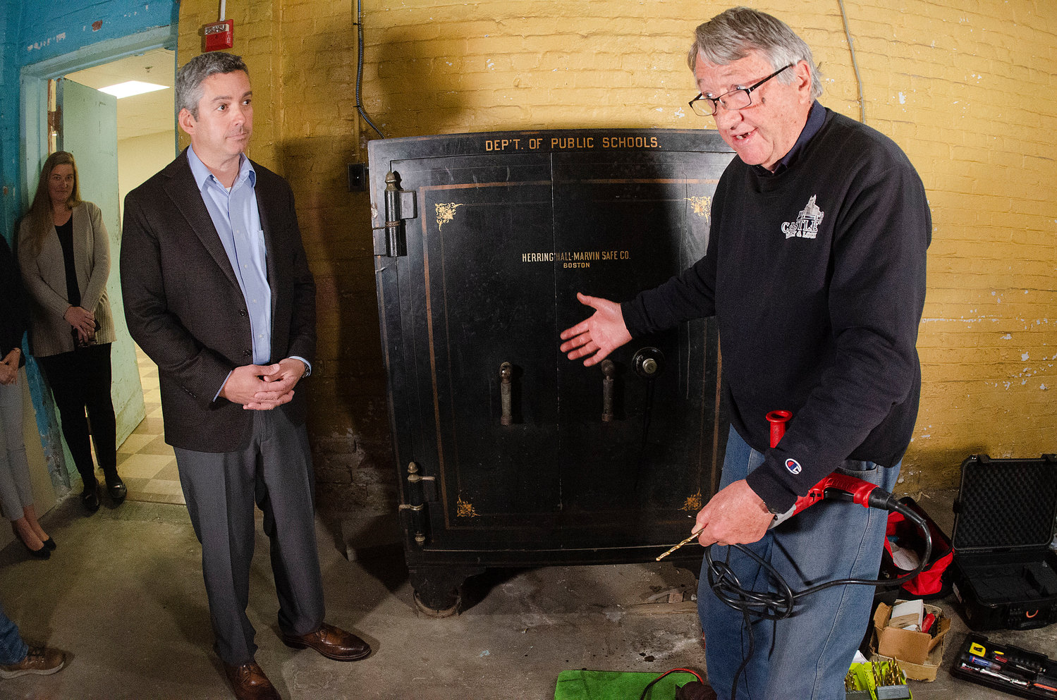 Town administrator Steve Contente looks on as professional safecracker  Francesco Therisod  explains the procedure of opening the safe to a live audience.