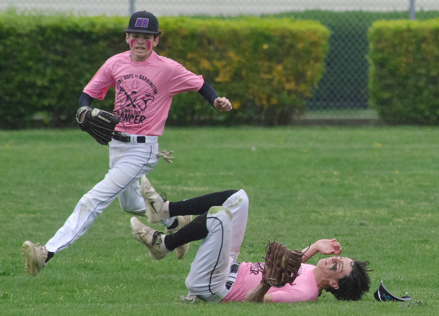Ethan Santerre (left) runs in to aid center fielder Aidan Ramaglia after he dove and made a catch to record an out during their Strike-Out Cancer game on Friday.