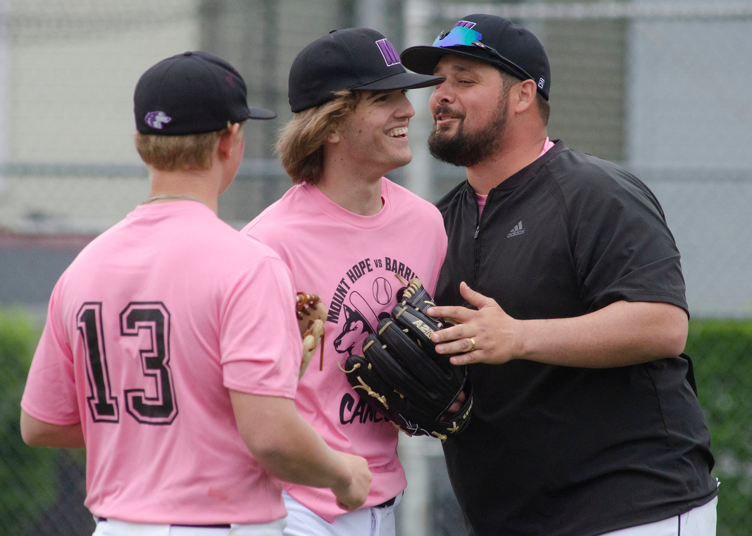 AJ Jones (left) looks on as Brad Denson celebrates with head coach Mike Mazzarella after the pitcher got out of a jam in the first inning.