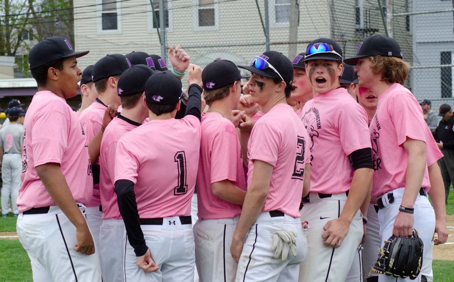 Matt Gale (yelling at right) and the team break out of a huddle before taking the field in the first inning.