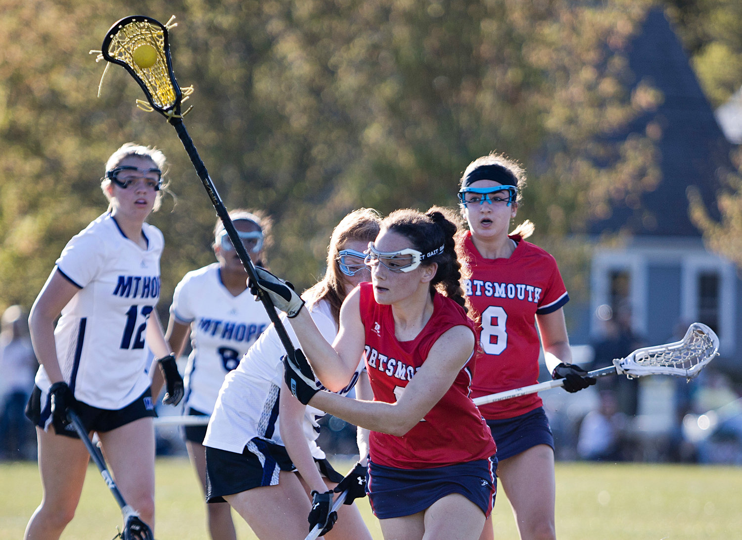 Elly Skeels, who had four goals against the Huskies, runs away from Mt. Hope defenders after catching a pass.