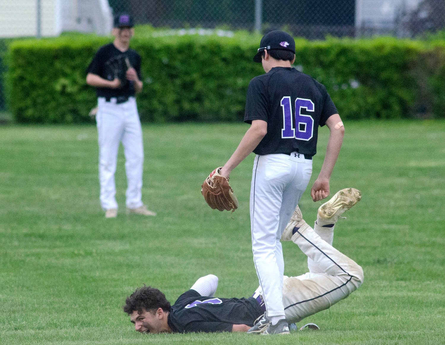 Infielder Dan Desilets looks on as second baseman Parker Camelo hits the ground hard after diving for a short fly ball. Camelo who previously injured his shoulder, rose to his feet and waved to the dug out that he was okay after the play.