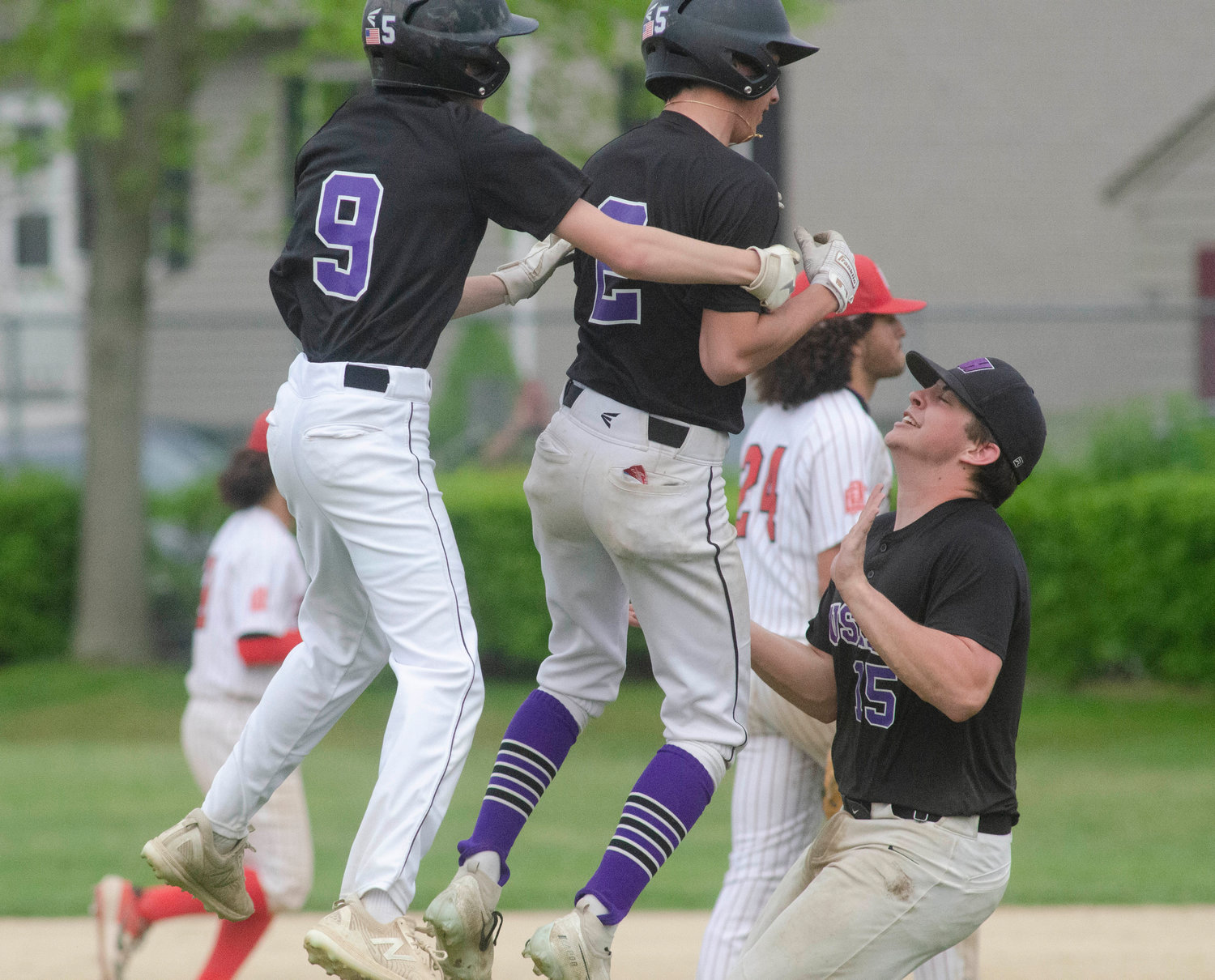 Ethan Santerre (left) and Jack Standish are the first to celebrate with Aidan Ramaglia (middle) after his game winning hit.