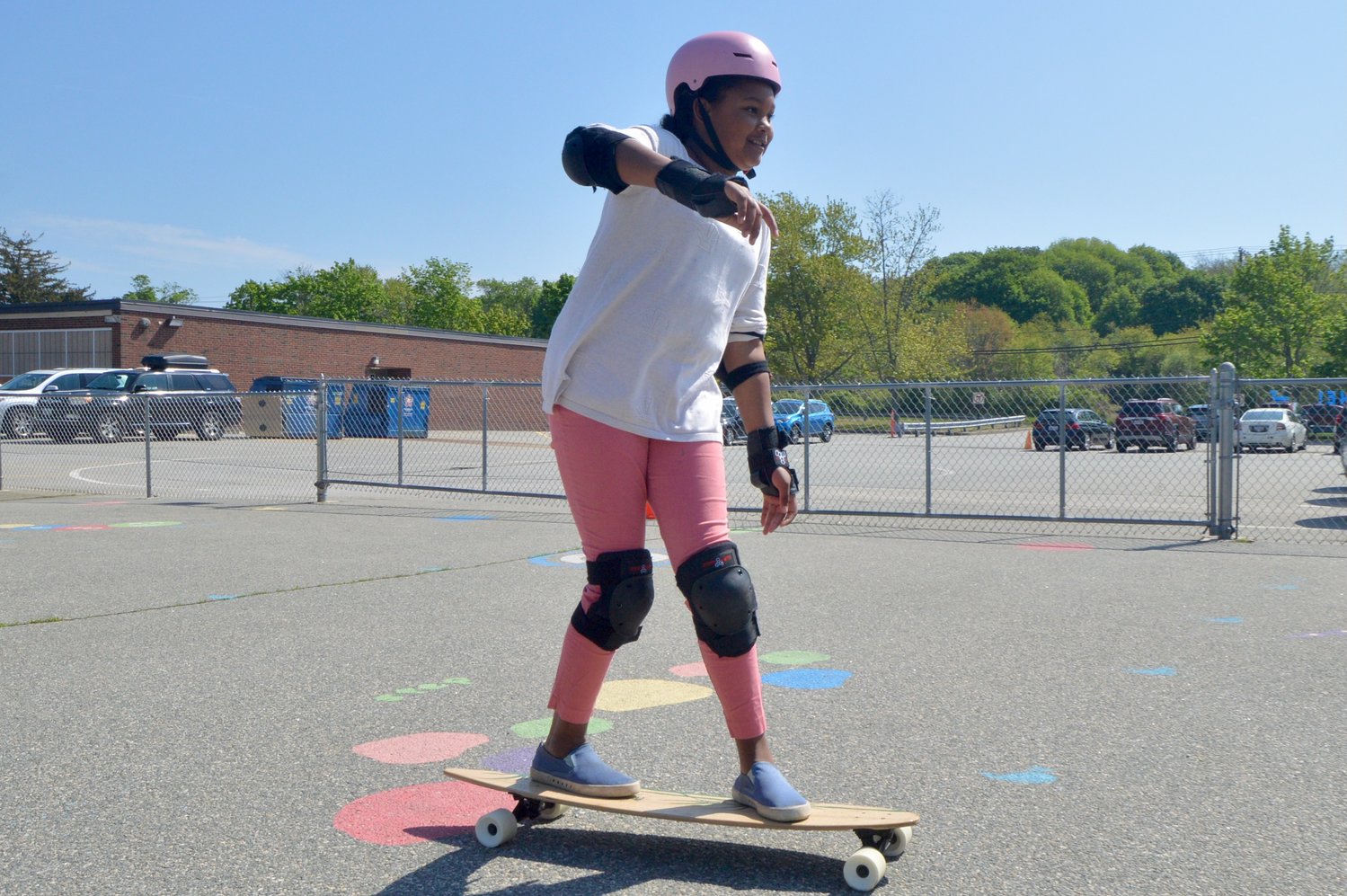 Ellie coasts on the longboard during P.E. class in the Melville School parking lot on Monday.