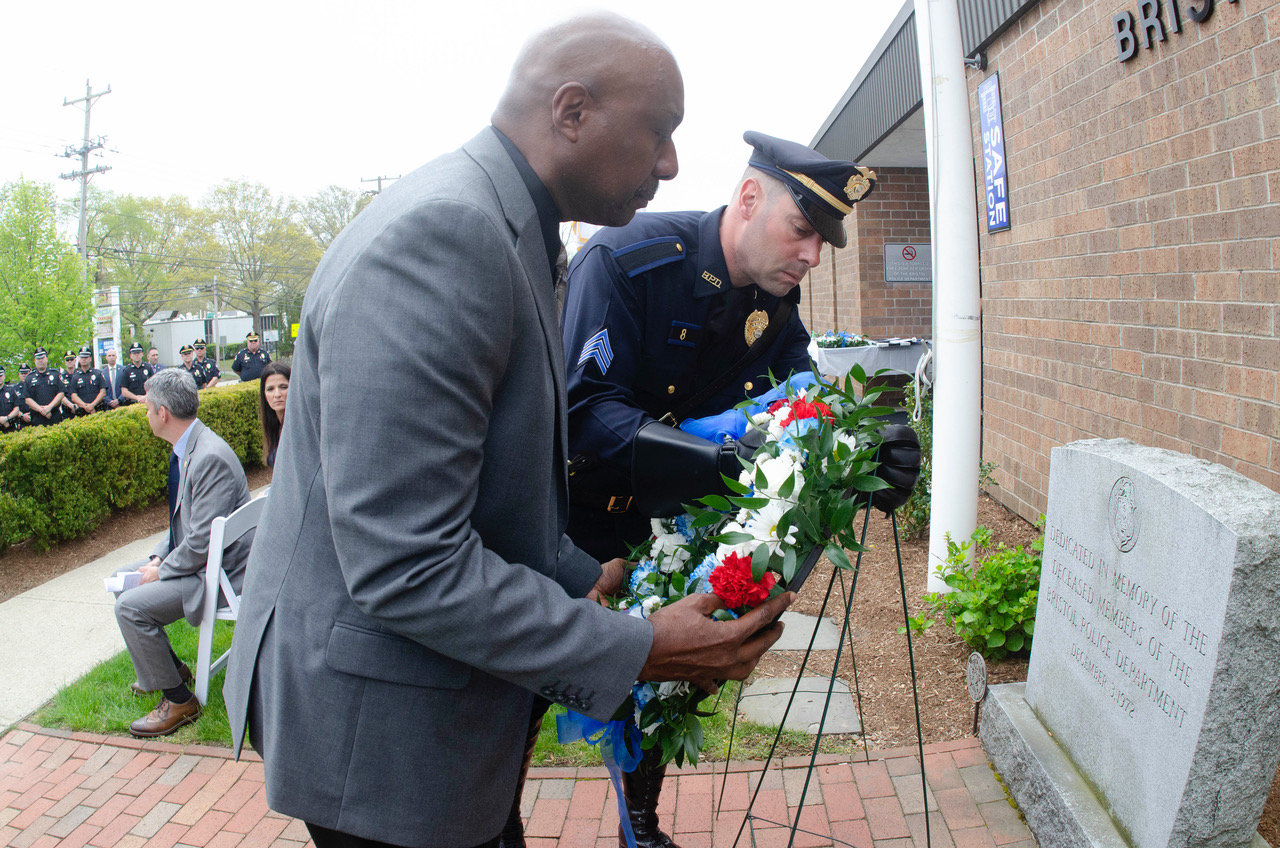 Accompanied by Sgt. Paul Medeiros, Emanuel Jean-Georges, father of the late Richard Jean-Georges, lays a wreath in his honor at the Bristol Police Memorial.