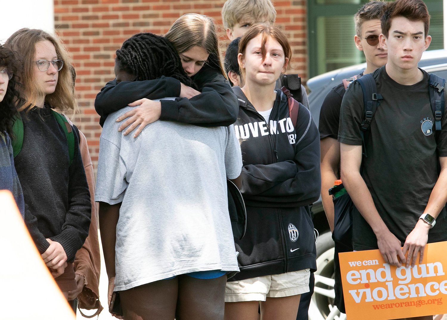 A friend comforts Aby Diallo after she and other students spoke against gun violence in front of Barrington High School on Thursday afternoon.