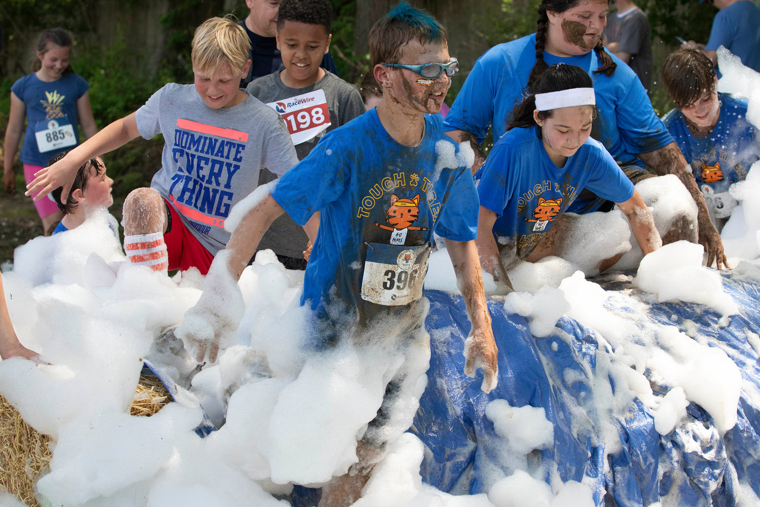 Jackson Gill (middle) leads a group of competitors through the “carwash” portion of the Tough Tiger adventure race at Hampden Meadows School on Sunday.