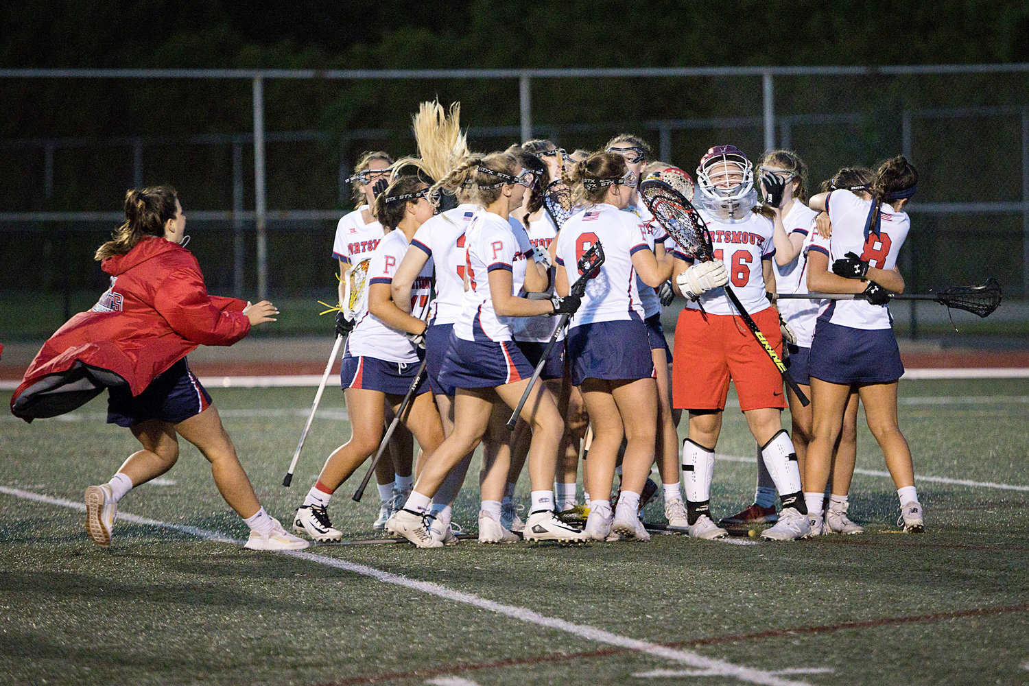 The Patriots surround goalie Emmy O'Connor after coming back to win, 15-14, in the Division II semifinals against Cranston West.