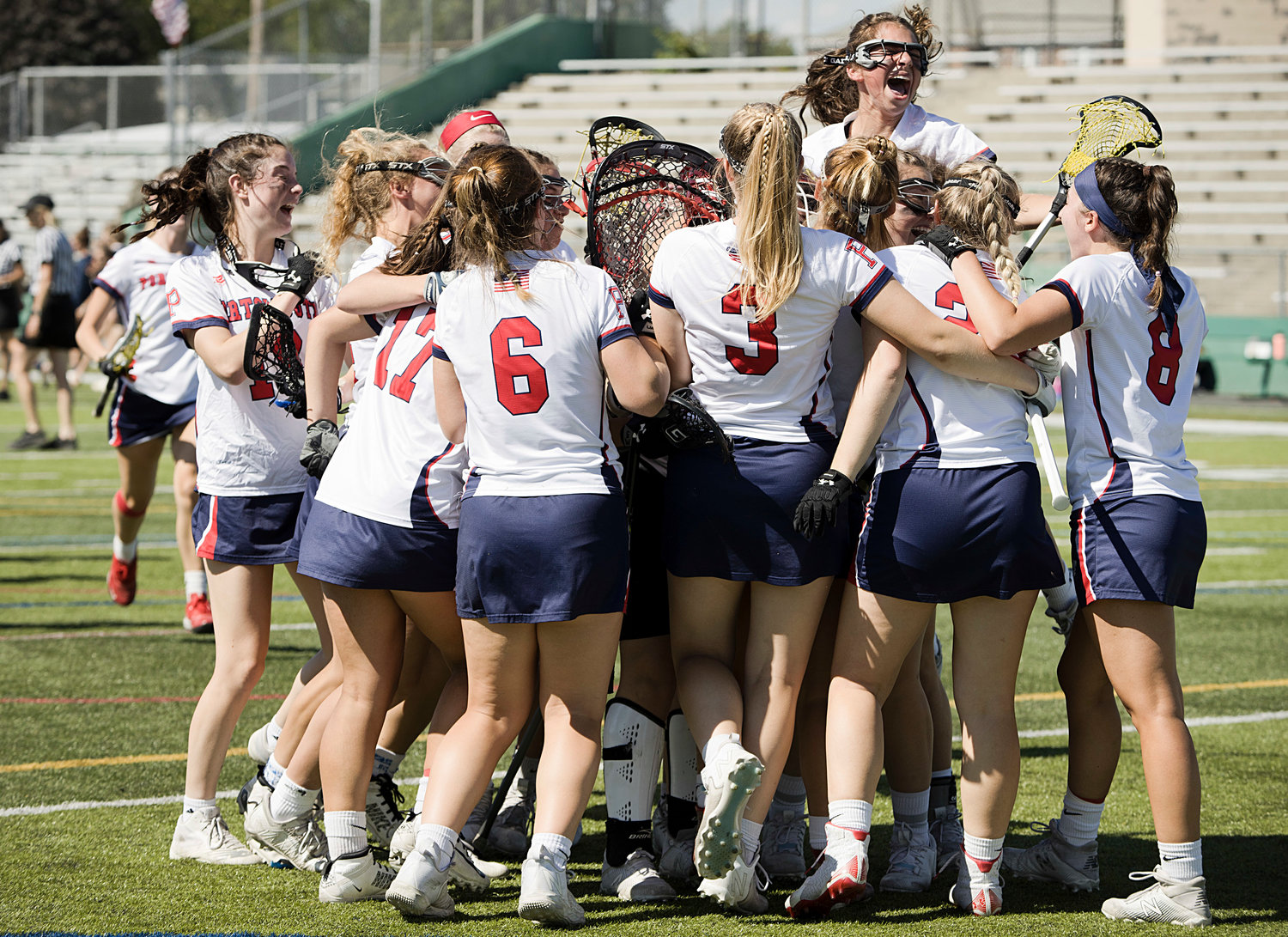 Members of the PHS girls’ lacrosse team storm goalie Emmy O'Connor after beating Burrillville in the Division II final on Sunday at Cranston Stadium.