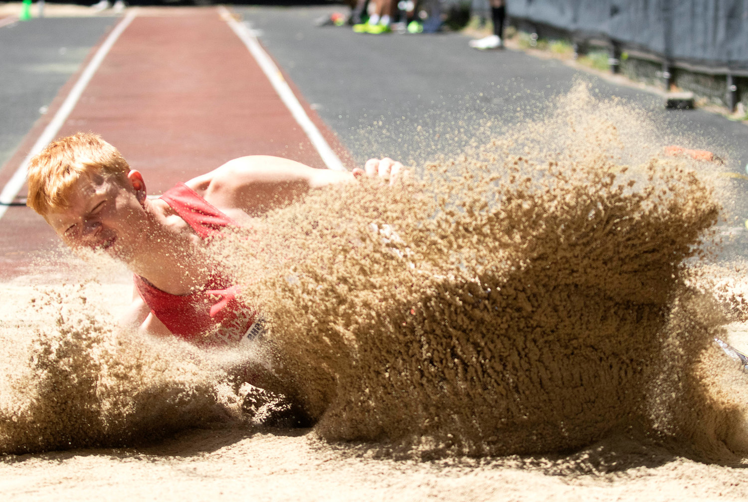 Colby Fahrney splashes down in the long jump, in which he came in fourth place.