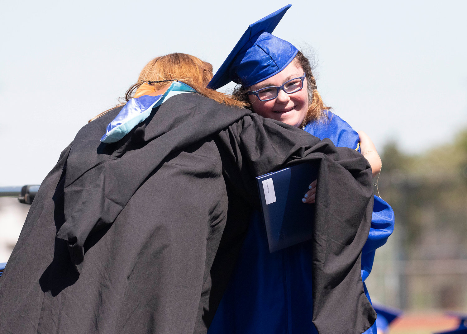 Caroline Friedman (right) gets a hug after receiving her diploma during the graduation ceremony at Victory Field on Sunday, June 5.