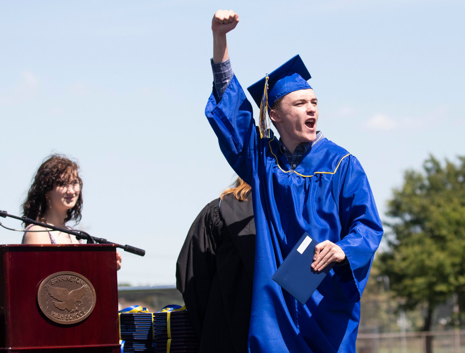 A Barrington High School graduate pumps his fist into the air during the graduation ceremony at Victory Field on Sunday, June 5.
