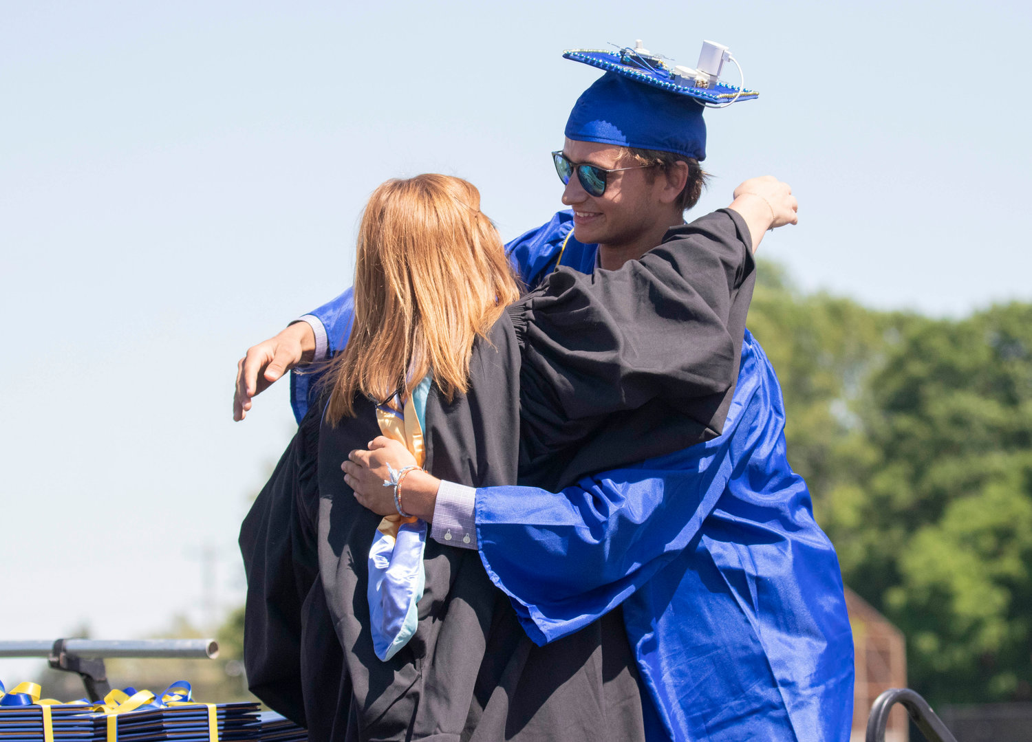 A Barrington High School graduate receives a hug during the graduation ceremony at Victory Field on Sunday, June 5.