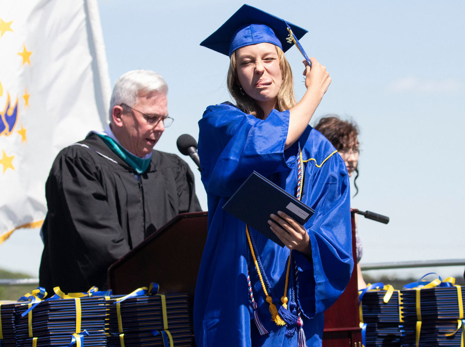 A Barrington High School graduate sticks out her tongue during the graduation ceremony at Victory Field on Sunday, June 5.