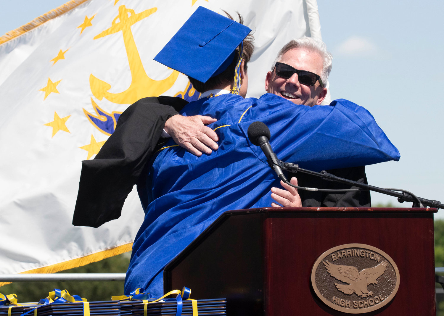 Graduating senior Jack Culton gives longtime BHS Principal Joe Hurley a hug during Sunday’s ceremony. Hurley is retiring at the end of the school year.