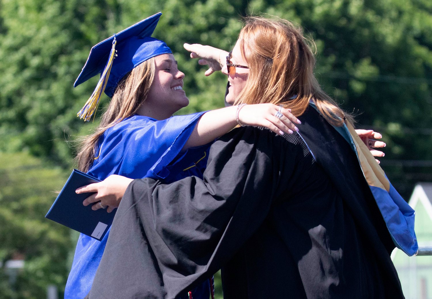 Allison Pfeffer (left) gets a hug while receiving her diploma.