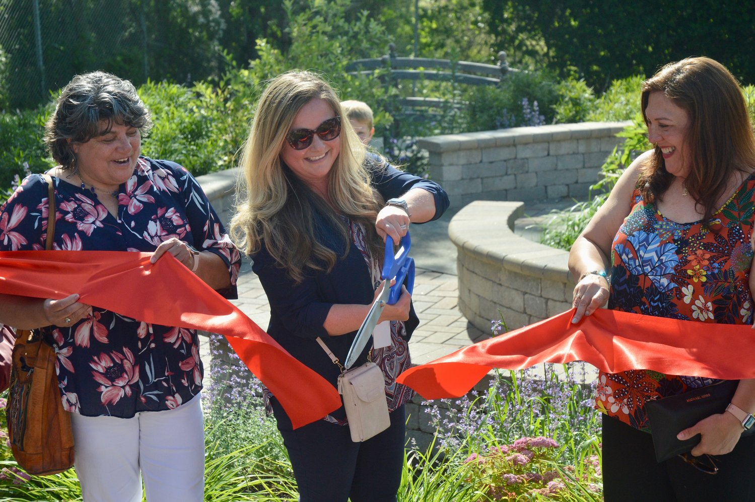 Deputy Superintendent Elizabeth Viveiros, who was principal at Melville School when the outdoor learning space was being planned and built, cuts the ribbon during a brief ceremony on Friday.
