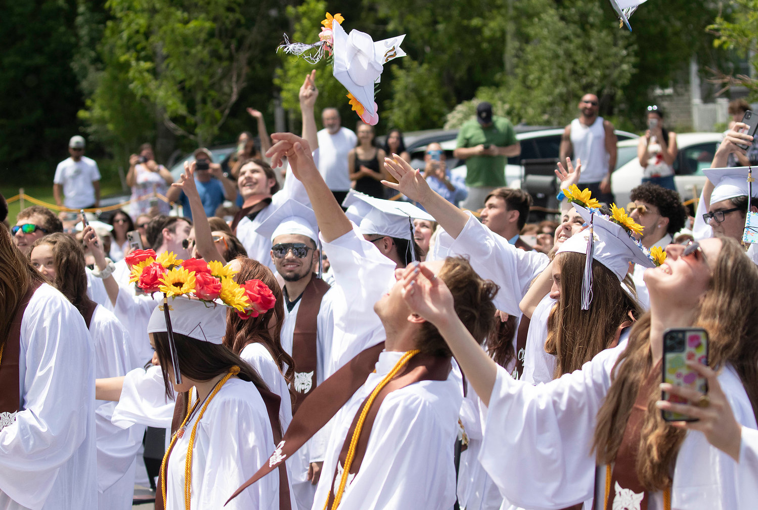 Graduates throw their caps into the air after graduation. 