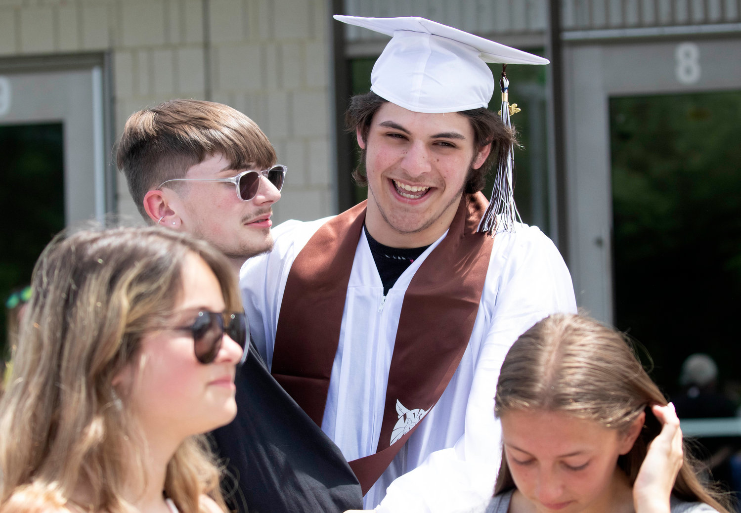 Graduate Ben Poitras receives hugs from family members after graduation. 