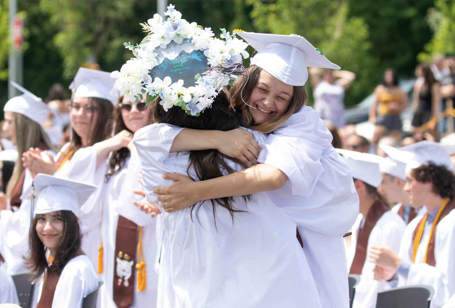 Raurie Laliberte (right) hugs fellow grad Madison Duarte as she walks back to her seat after receiving her diploma. 