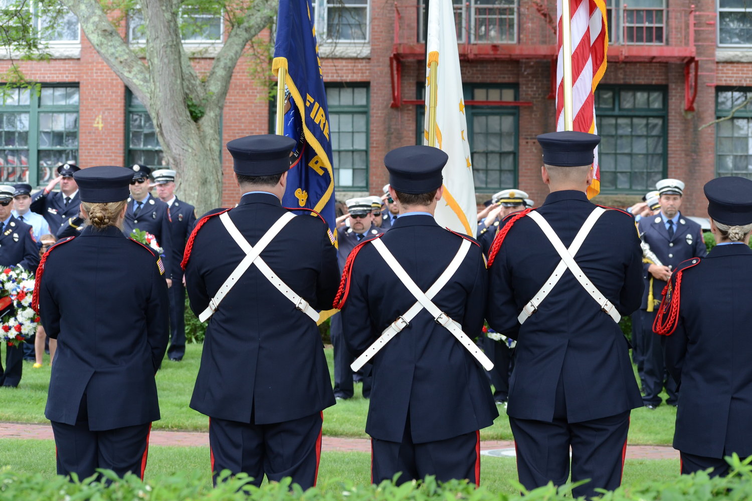 Firefighters salute the flag during the National Anthem prior to the commemoration ceremony at Firemen’s Memorial Park on Sunday.