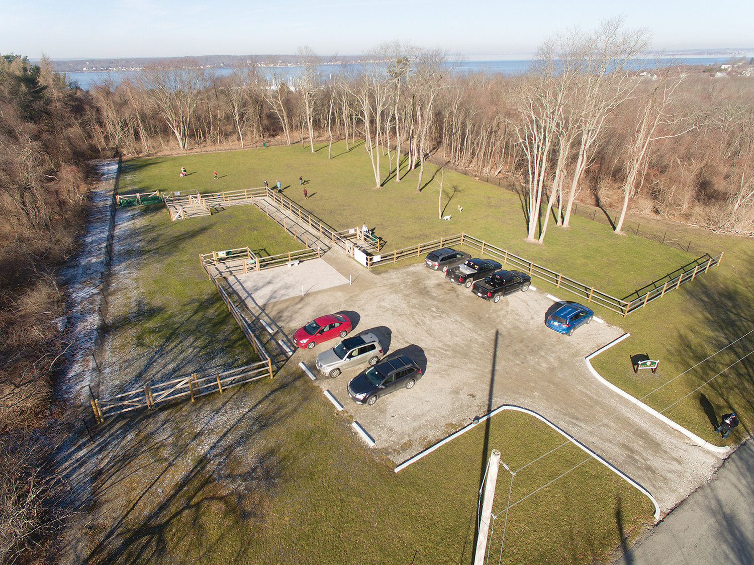 Aerial photograph of dog park shows the parking lot, small dog area at left and large dog area at right.