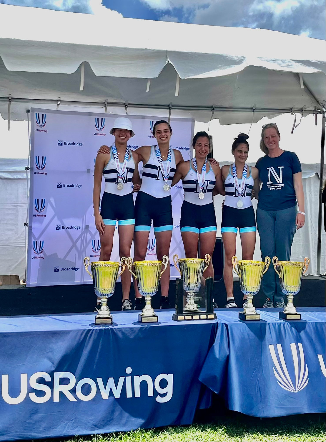 Sophia Haisman, Maude Smith-Montross, Gianna Vigliotti, and Estelle Pivorunas (from left to right) pose for a photo with their coach Daniela Roop, after receiving their medals.